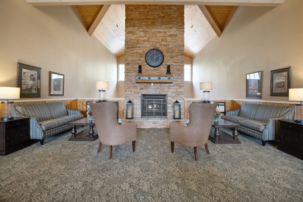 Two chairs facing a fireplace with couches on either side.