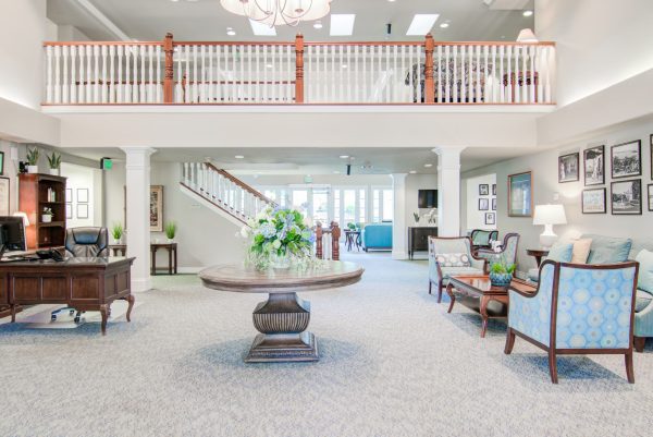 A wider view of the lobby, with a round table in the middle and a staircase in the background