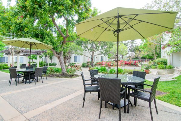 An outdoor seating area with tables, chairs, and umbrellas