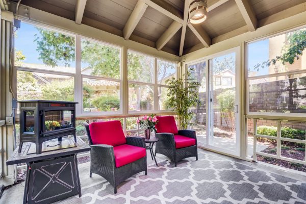 A sunroom with a table and chairs.