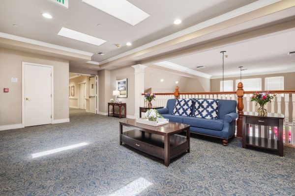 A seating area at the top of the staircase with a couch and a table.