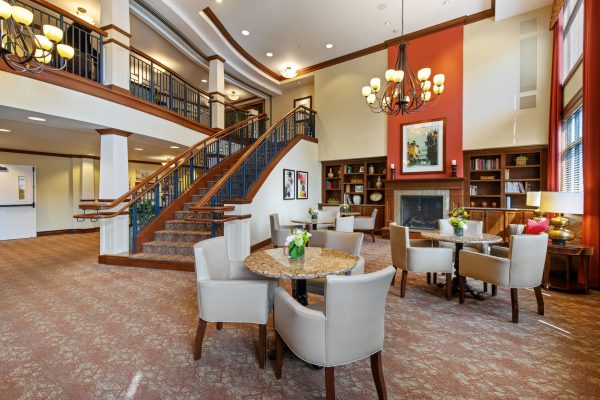 A grand stairway with tables and chairs off to the side.