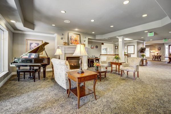 A seating area with a fireplace and grand piano