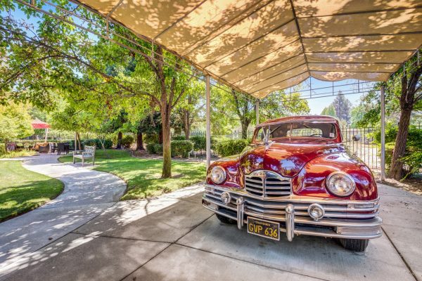 A red classic car in a carport