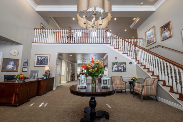 The main lobby of Aegis Living, with a large wraparound staircase