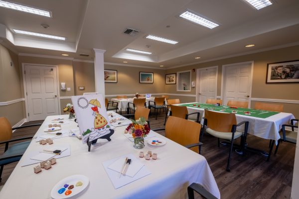 A painting room with tables, chairs, and painting supplies