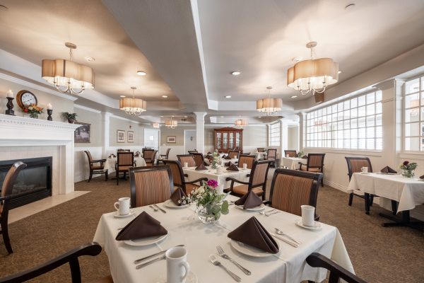 A large dining area with tables, chairs, and a fireplace