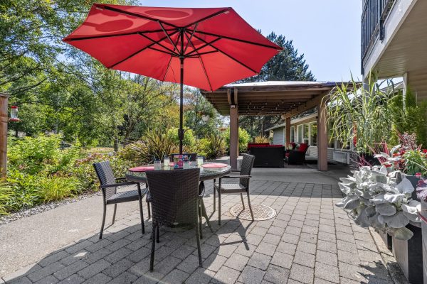 An outdoor seating area with a table, chairs, and umbrella