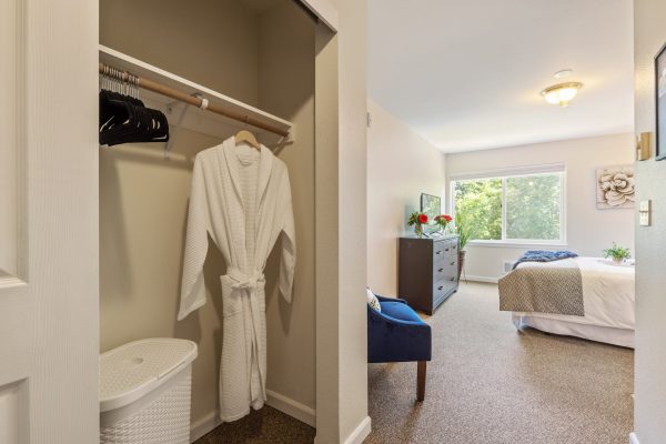 A closet with a white robe hanging in it