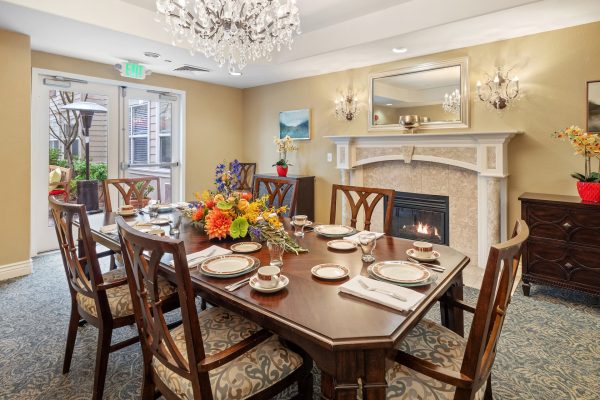 A formal dining table with a fireplace in the background