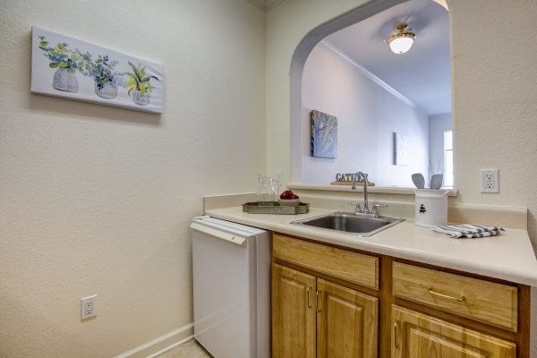 A small kitchen with an open window into the living room