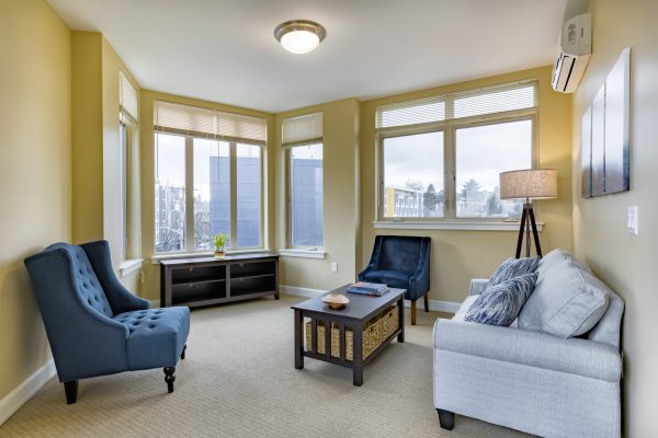 A small living room with a couch, armchairs, and a coffee table