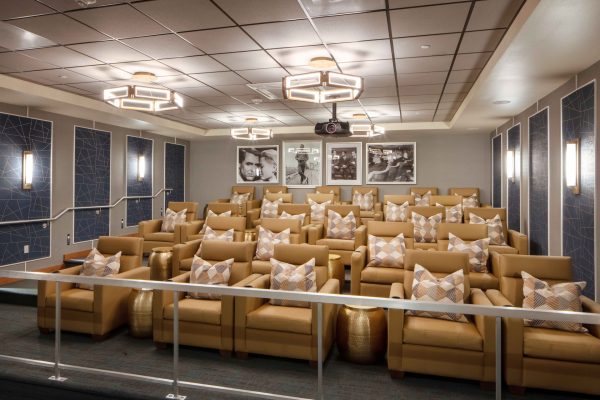 A movie room with lots of comfortable chairs