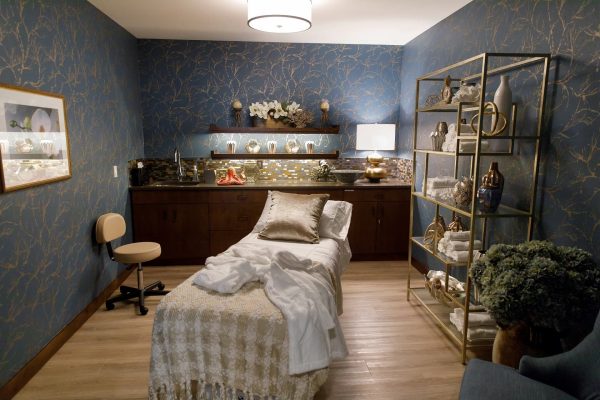 A small massage room with a cozy massage table in the middle