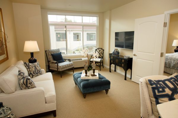 A living room with a couch, chairs, and ottoman