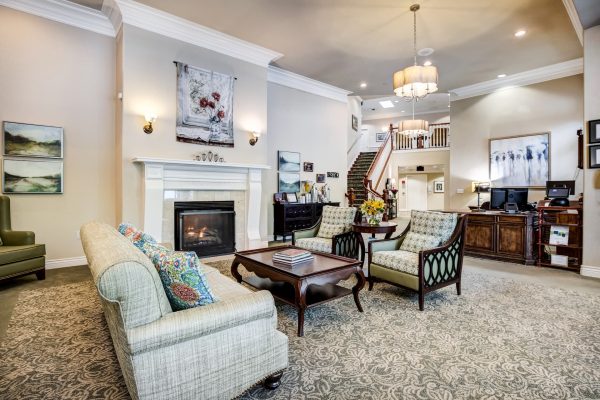 A cozy seating area with a couch, two chairs, a coffee table, and a fireplace.