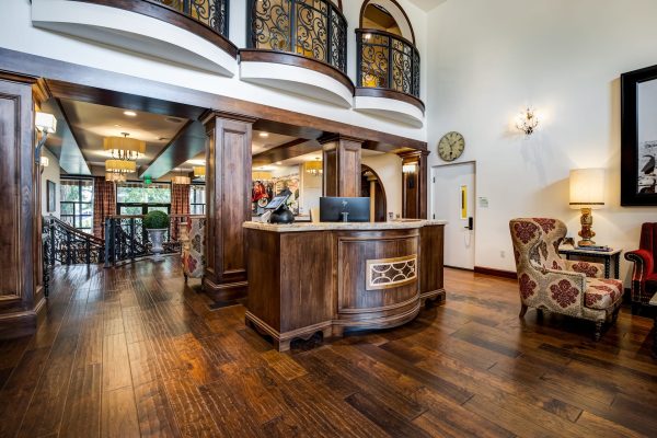 The lobby, with elegant black balconies, a desk, and armchairs