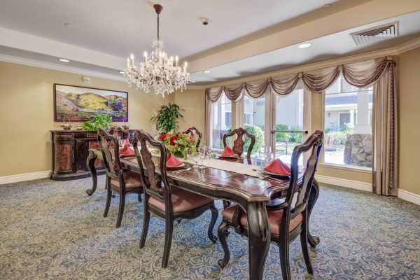 A formal dining table with large windows in the background