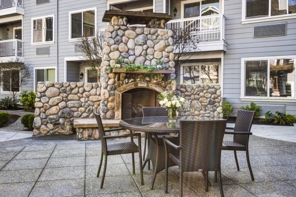 A large outdoor fireplace with a table and chairs in front of it