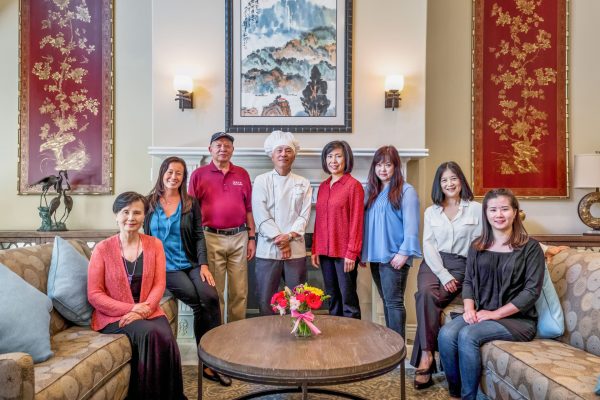 A group of people sitting and standing in front of a mantle in the lobby.