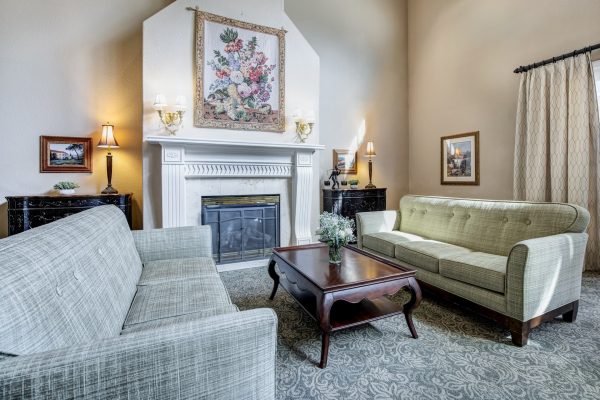 A room with two couches facing each other, a coffee table, and a fireplace