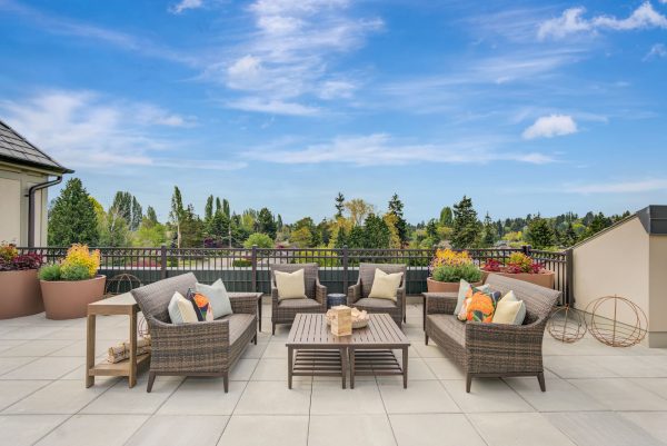 An outdoor seating area with a bright blue sky and lots of trees in the background