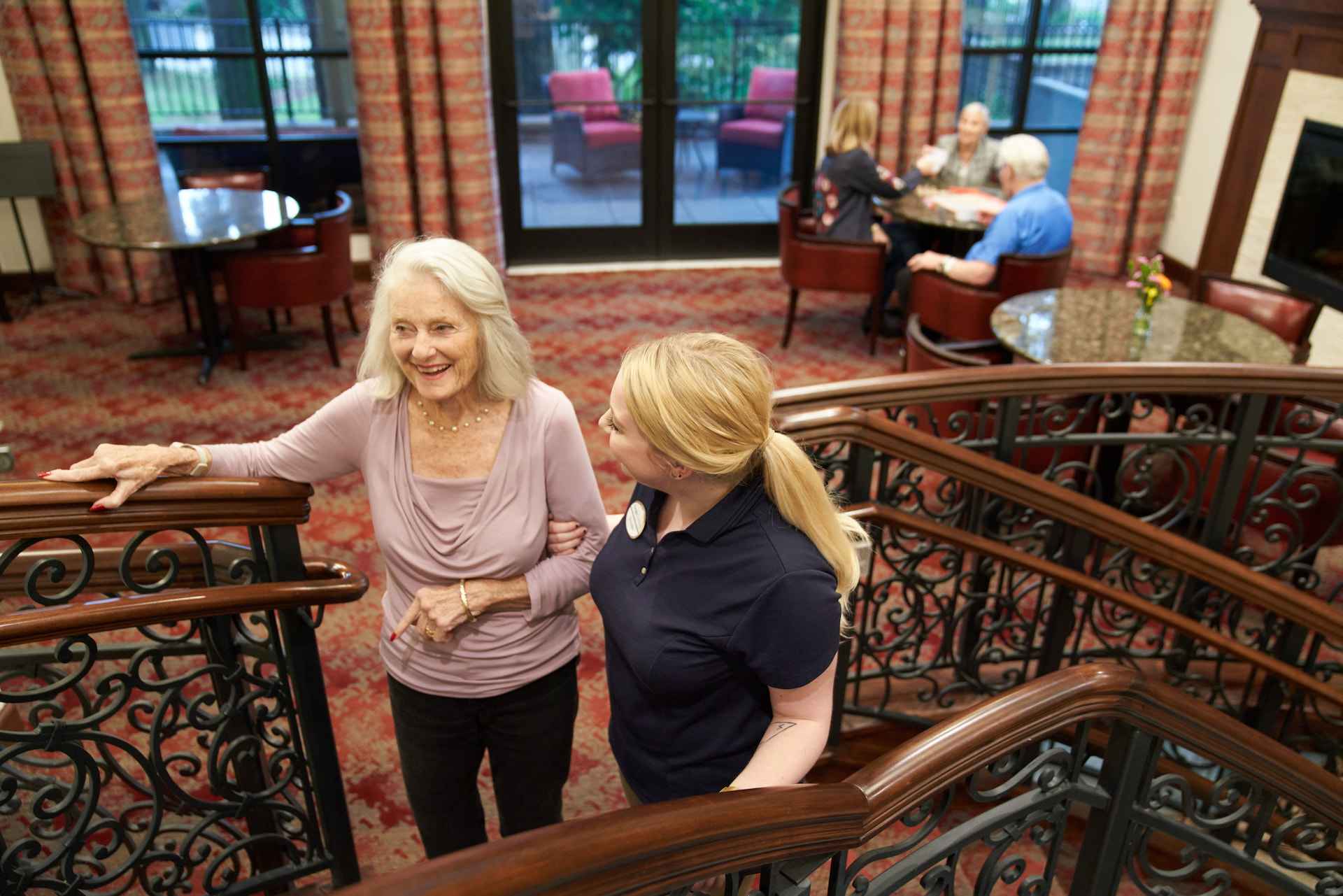 A resident walking up the stairs with an employee