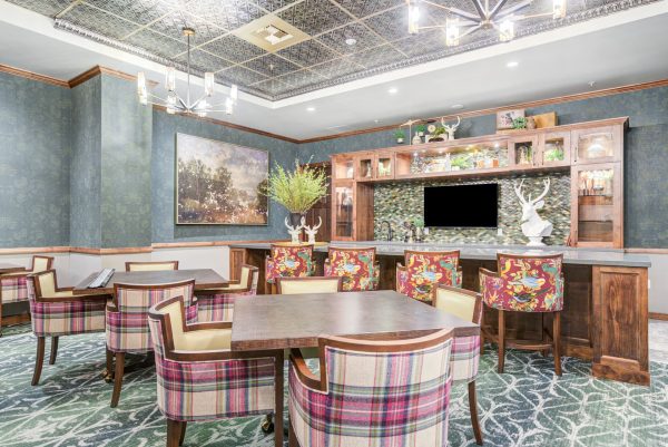 A colorful dining area with brown tables and plaid and floral chairs