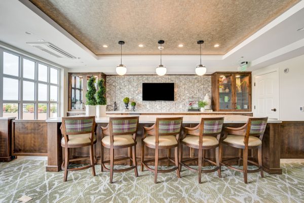 A bar area with chairs and a small television in the background