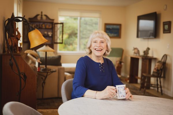 A resident sitting and smiling happily at the camera