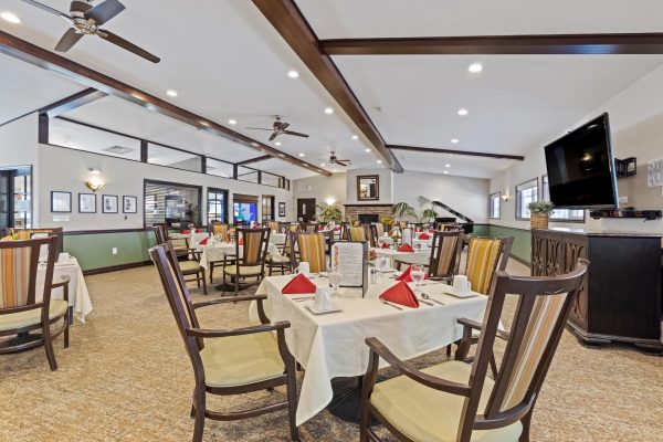 A large dining area with tables, chairs, and a television