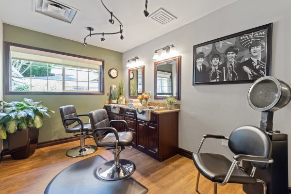 A barbershop with a large window and print of The Beatles in the background