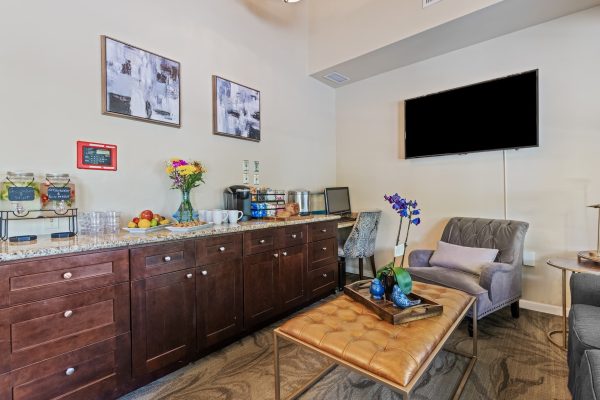 A coffee and snack station with a long counter, a couch and a chair, and a coffee table