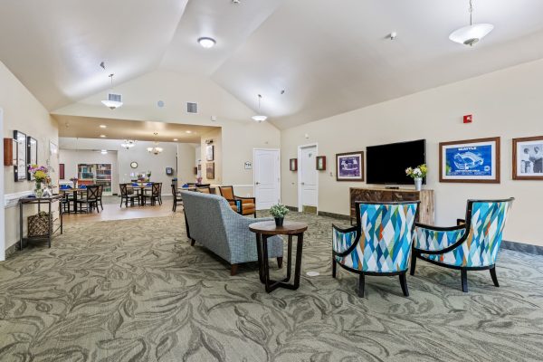 A seating area with a couch, chairs, and a television