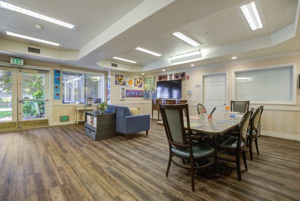 A large, open games room with a couch, television, and tables and chairs