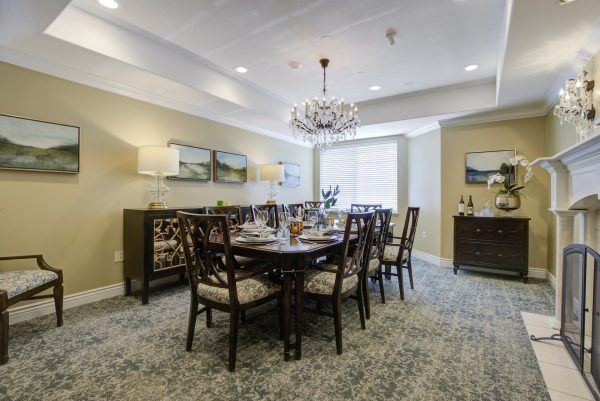 A large dining table and chairs in front of a fireplace