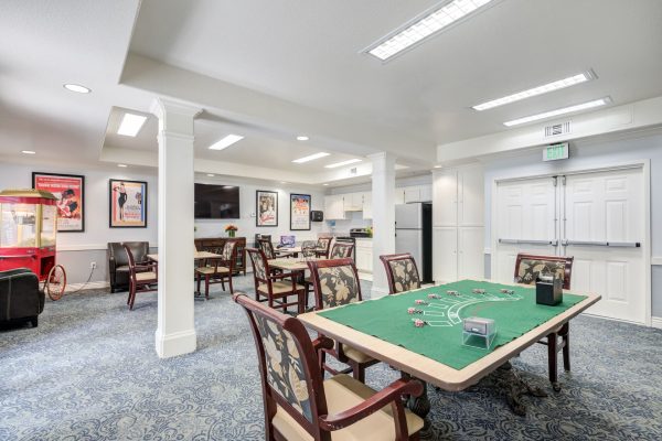 A games room with a card table and chairs, television, and popcorn machine