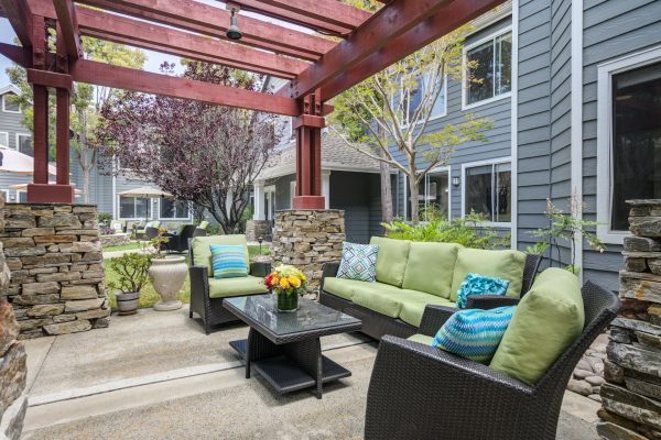 An outdoor seating area with a couch, two chairs, and a coffee table