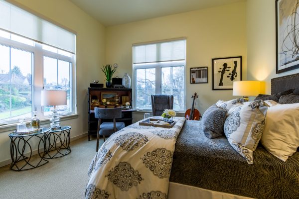 A large cozy bed facing large windows