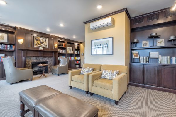 A sitting area with armchairs, built-in bookshelves, and a fireplace