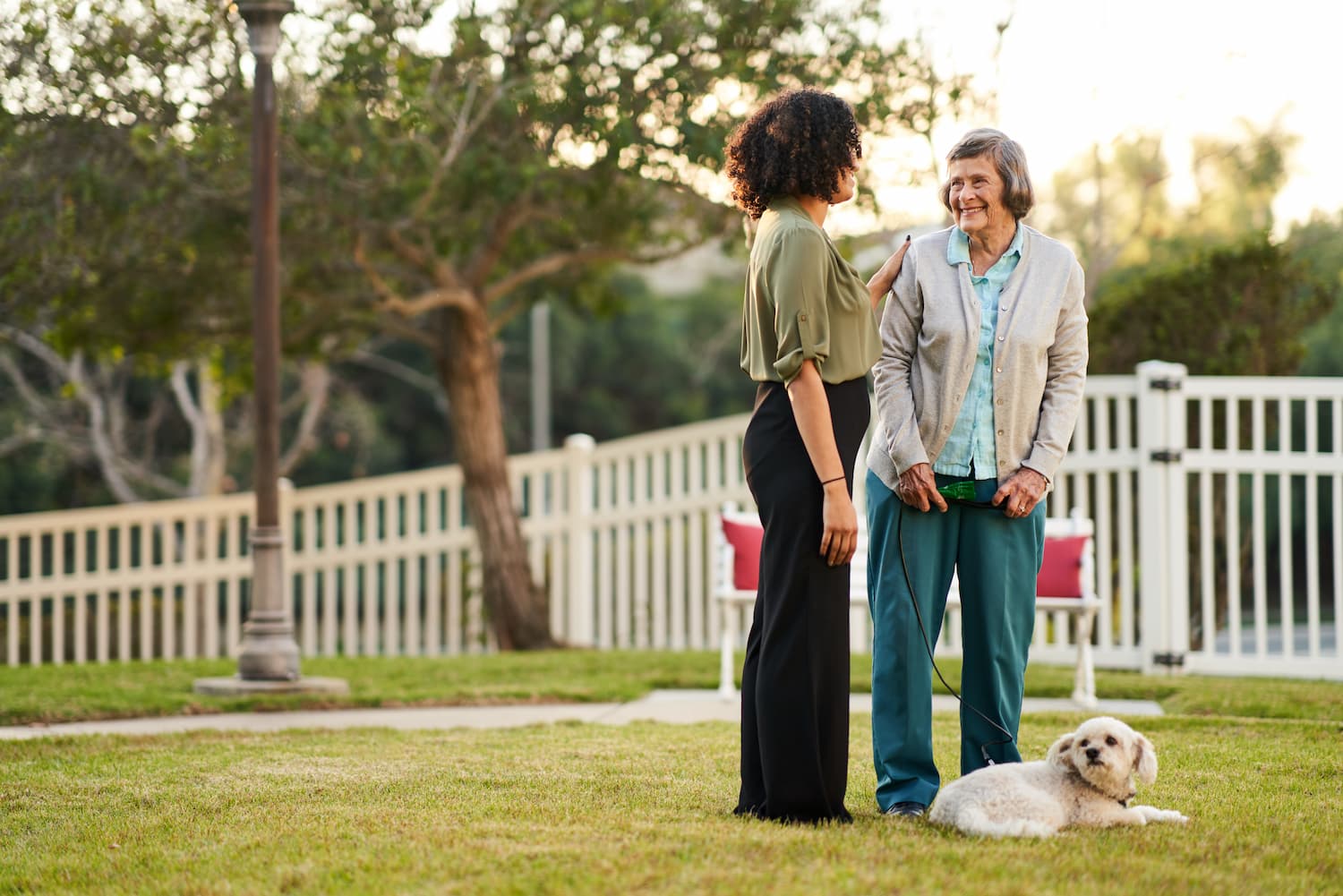 A resident with her dog talking to an employee