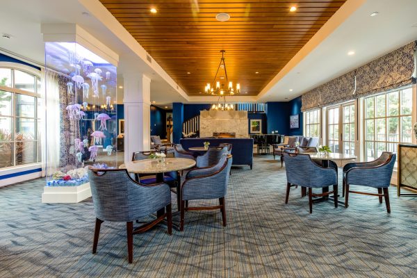 The lobby, with tables, chairs, and a large vertical aquarium