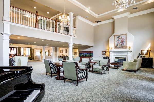 The back of the lobby, with a piano, armchairs, and a fireplace