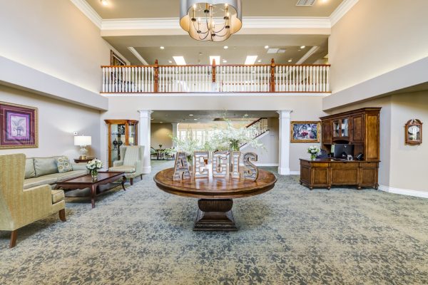 The spacious lobby, with a round wooden table, desk, couch, armchair, and coffee table