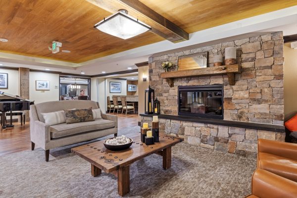 A large room with a couch, coffee table, two armchairs, and a fireplace