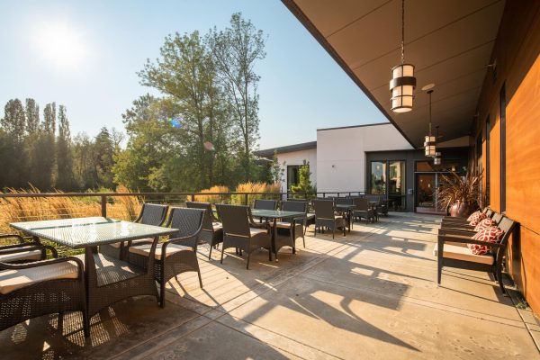 A large outdoor seating area with a blue sky and trees in the background.