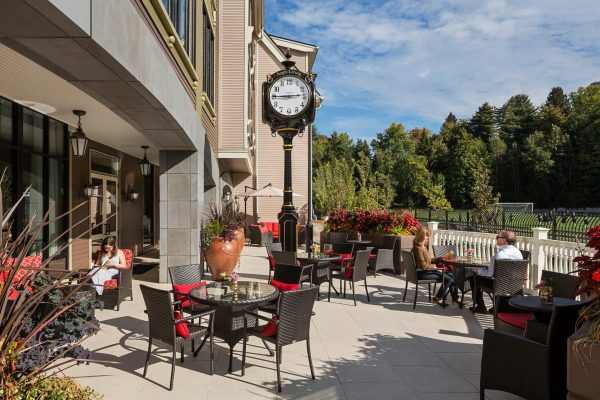 An outdoor seating area with chairs, tables, and a clock