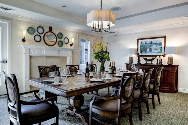 A large dining table with a fireplace in the background