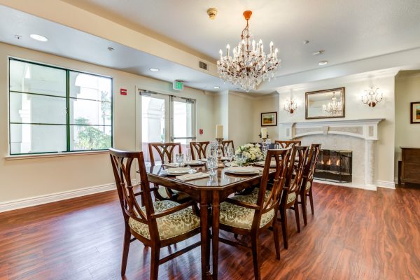 A dining table with chairs and a fireplace in the background