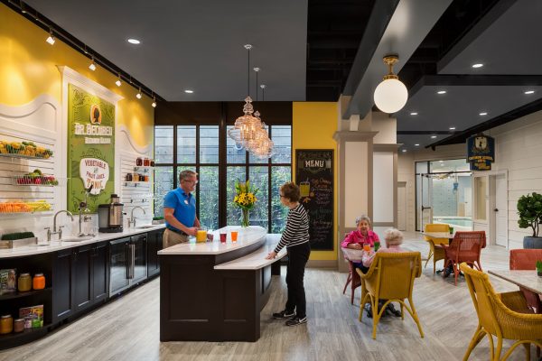 A resident getting food at breakfast area with an employee standing behind the counter